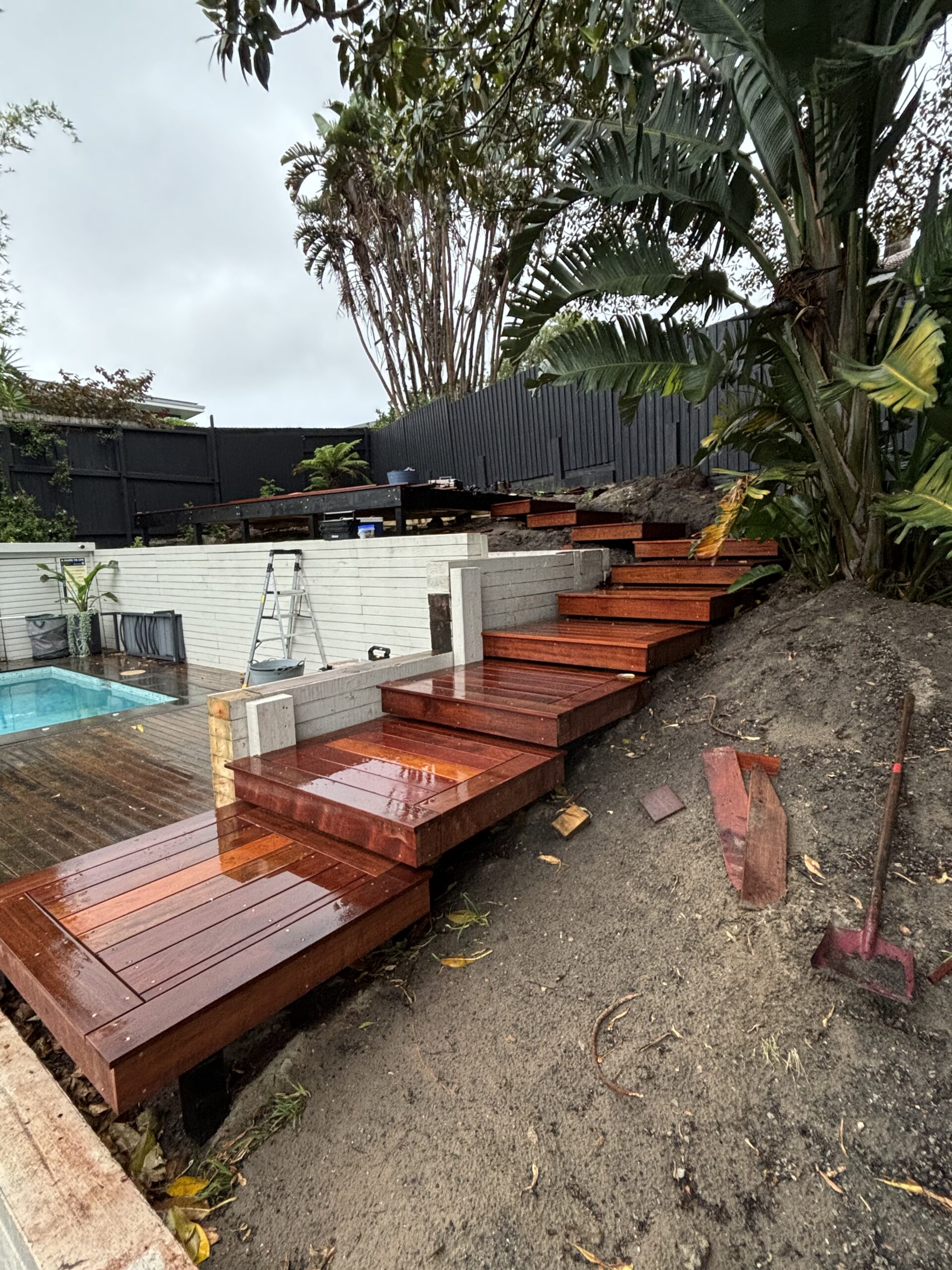 Construction in progress: floating Merbau timber steps being installed on steep Coogee hillside by The Decksmith
