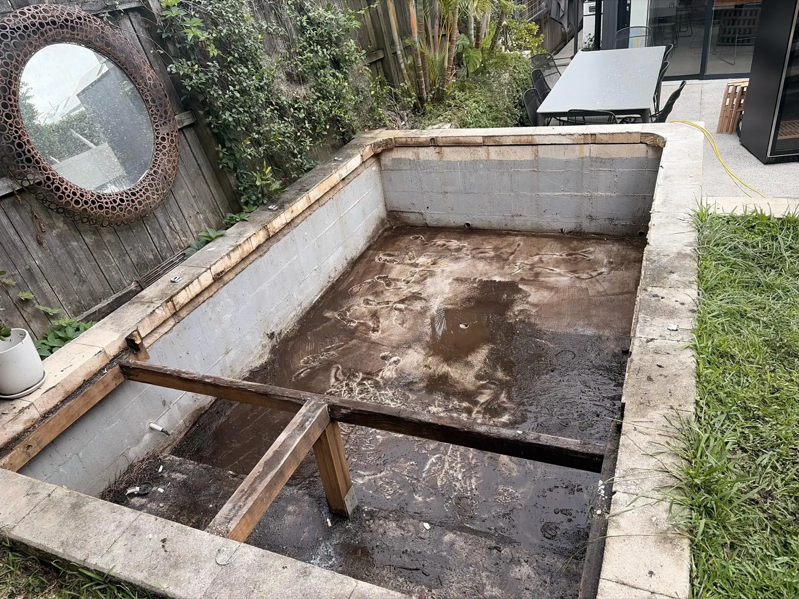 Empty concrete spa pit before conversion — the existing condition