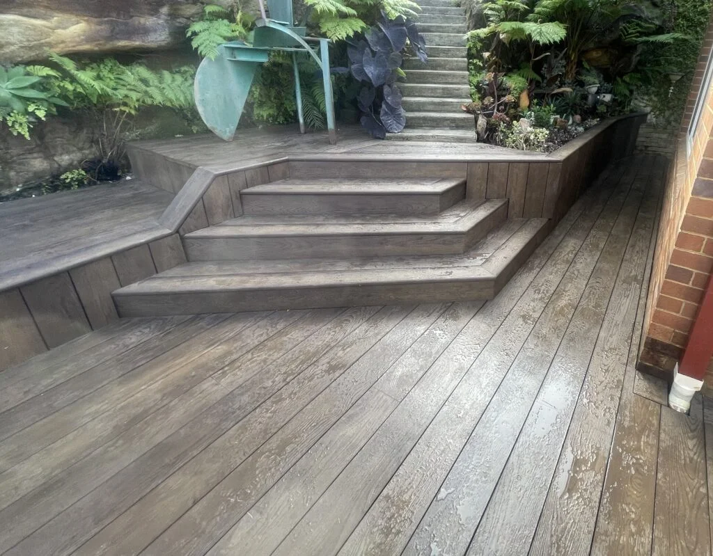 Millboard Antique Oak deck with built-in bench and timber-look stairs at Northbridge