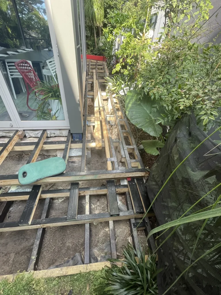 H4 90x90 post acting as a retainer in Maroubra, with the low framing coated in bitumen in-ground timber protector