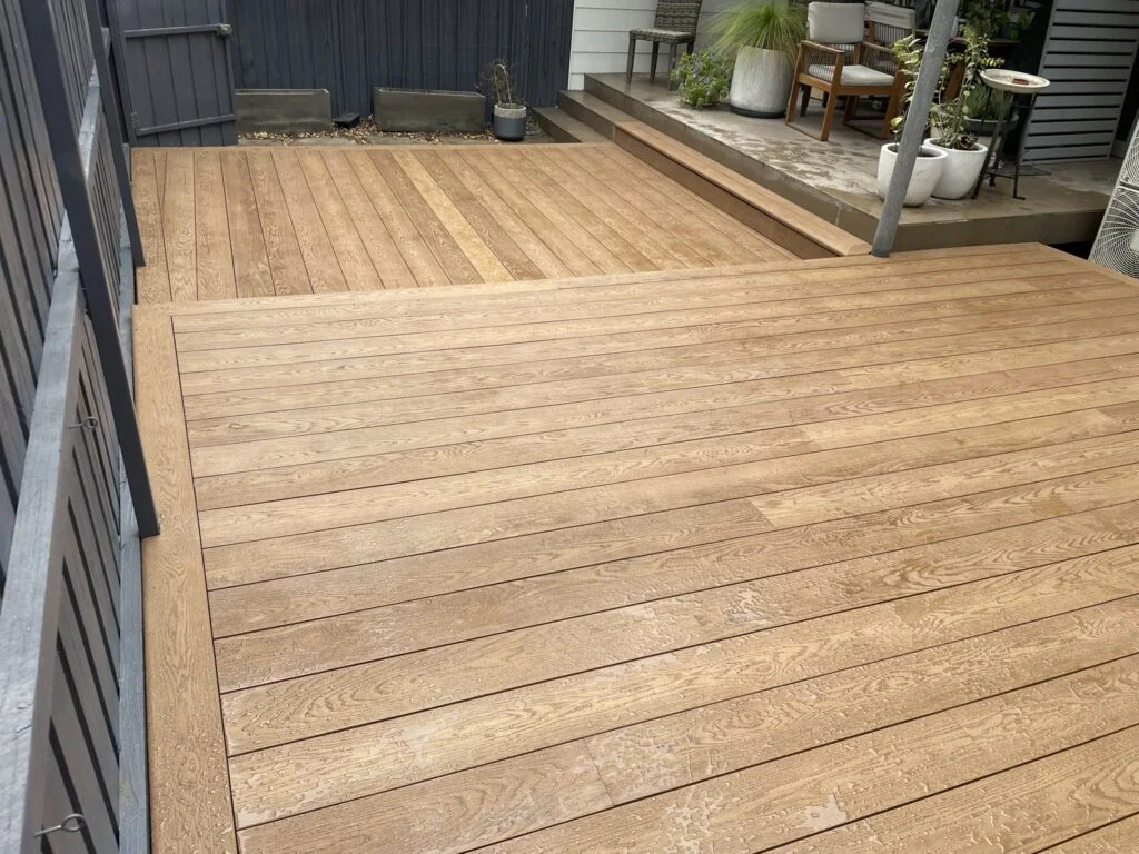 Finished Matraville Millboard Coppered Oak deck viewed from the house, showing both levels and the running step