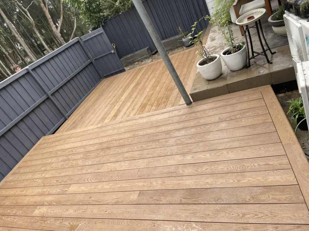 Completed split-level Millboard Coppered Oak low deck in a Matraville courtyard with opposing board directions