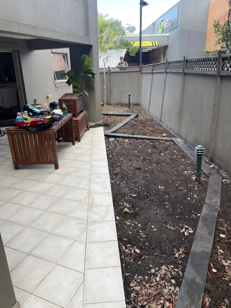 Tiled patio and garden before the deck, viewed over the fence, Rose Bay